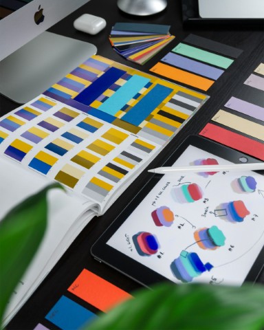 Creative graphic design workspace with logo designs, color palettes, and branding materials